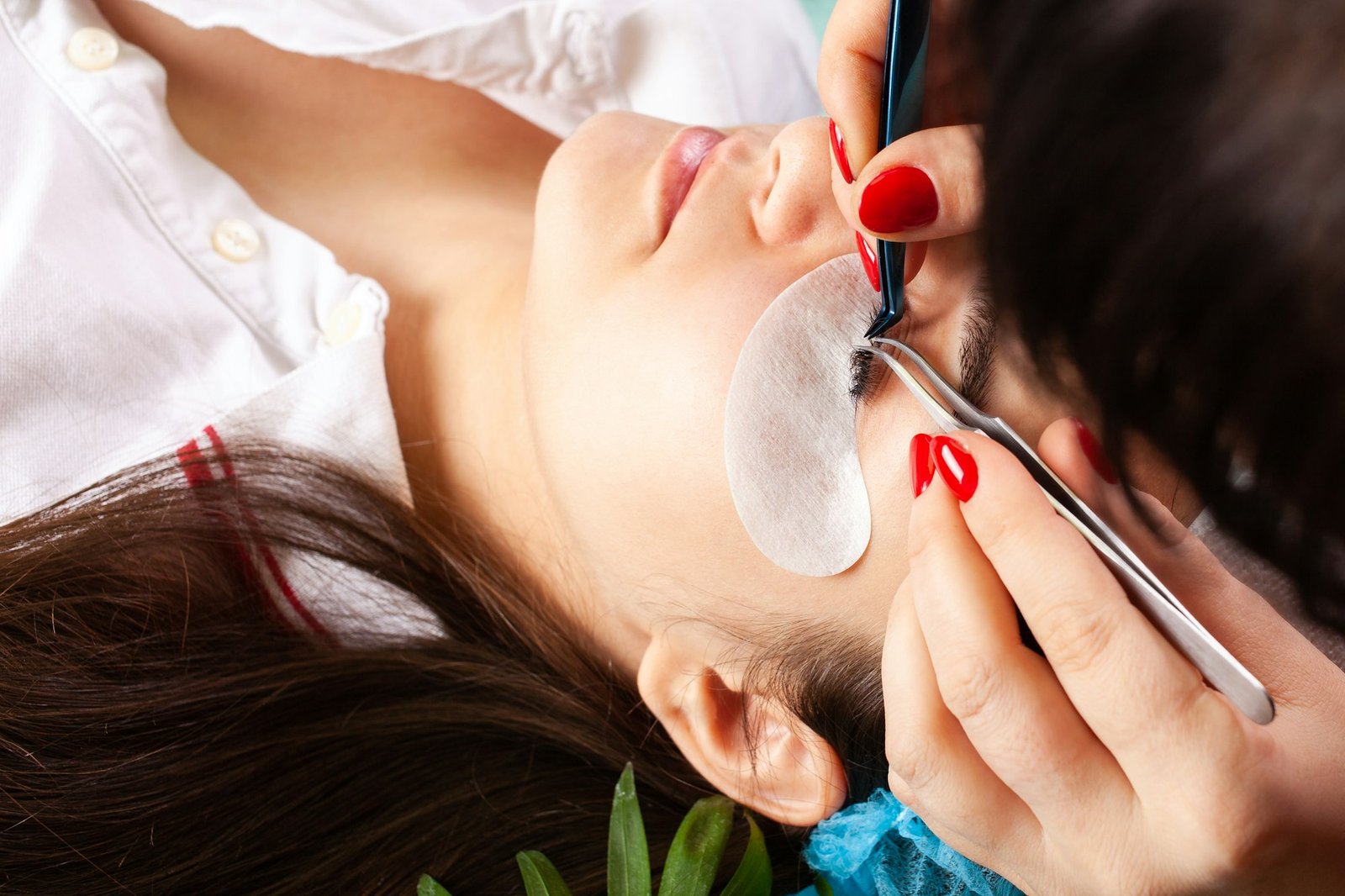 Eyelash extensions in a beauty salon. A young girl lies on a couch